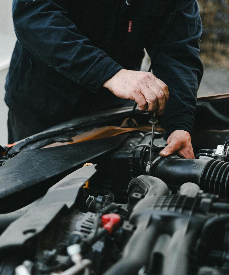 Mécanicien en train de travailler sur un moteur de voiture au Garage André Plante & Fils.